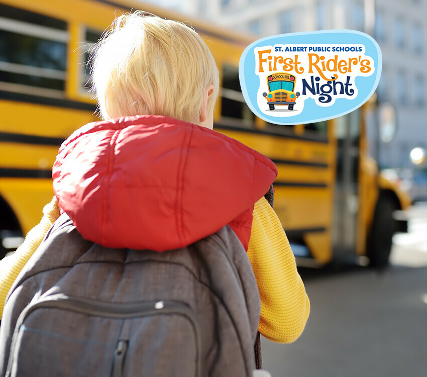 Young child in front of a yellow school bus